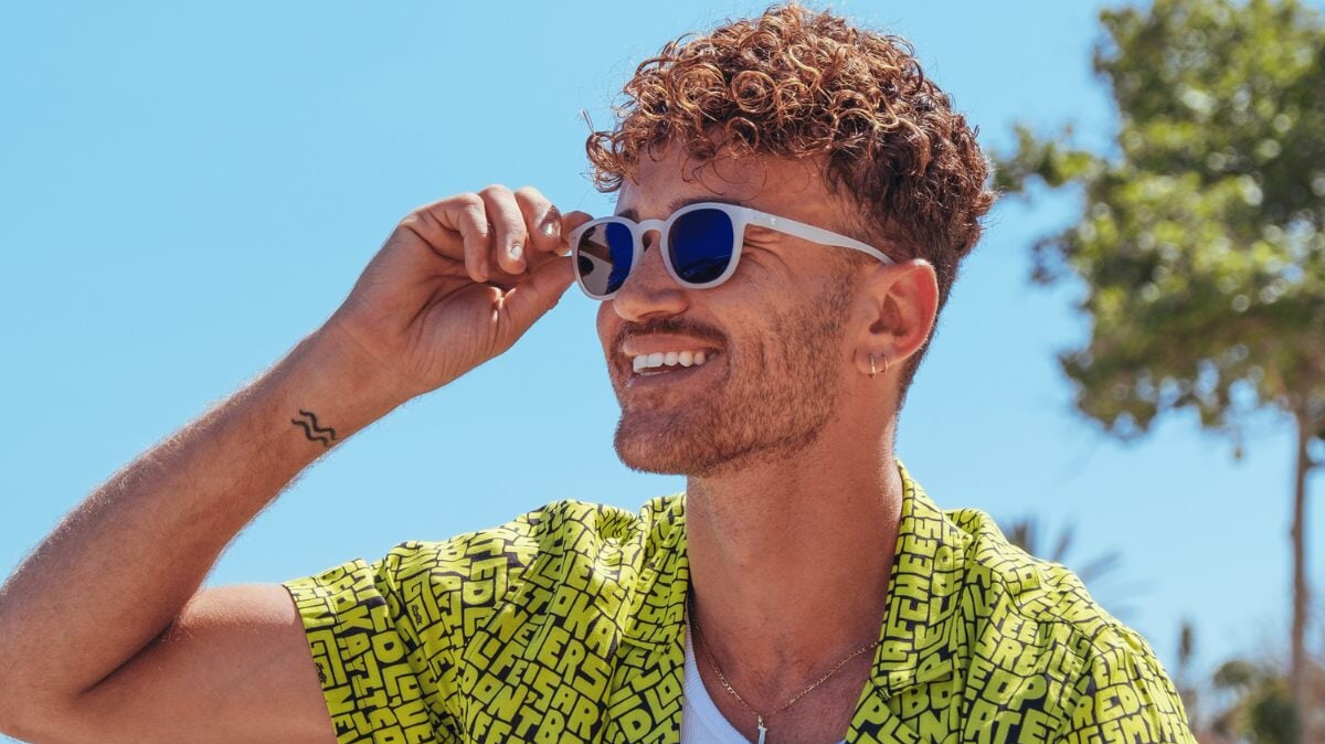 un homme portant des lunettes de soleil Horus X à la plage