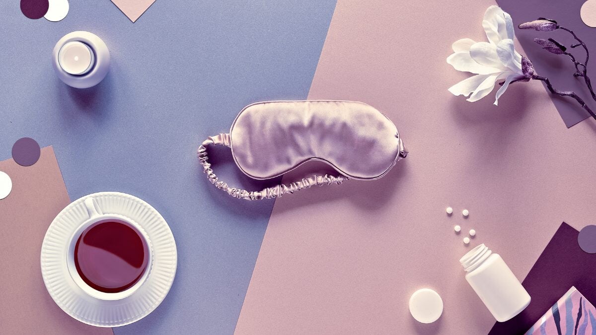 Qualité du sommeil. Masque de sommeil, somnifères, bougie parfumée et tasse de thé apaisant. Pose plate en papier bicolore argent, rose, beige et marron. Texte Bonne nuit sur le masque.