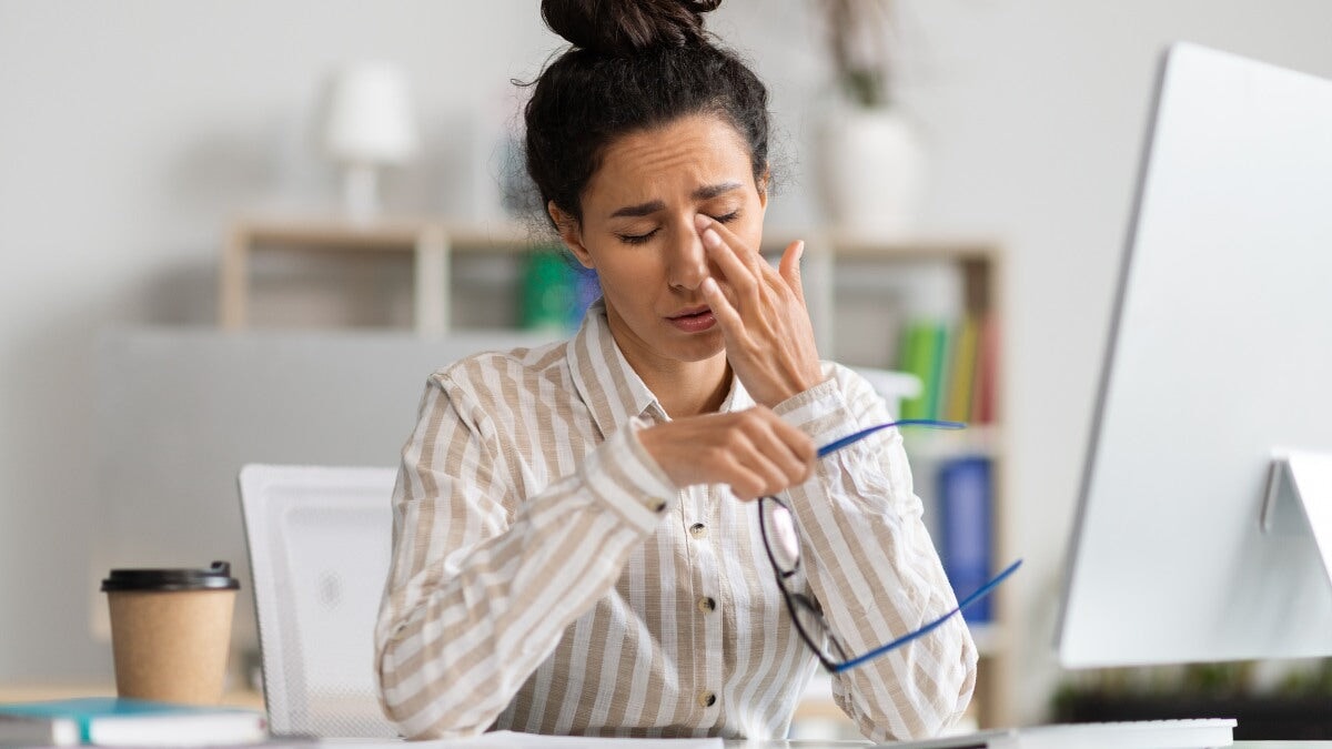 Une femme gestionnaire fatiguée ressent de la douleur, de la fatigue oculaire, se frotte les yeux secs et irrités, fatiguée par le travail sur ordinateur au bureau
