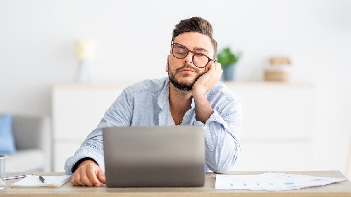 un jeune homme portant des lunettes horus x anti lumière bleue faisant une sieste à son bureau