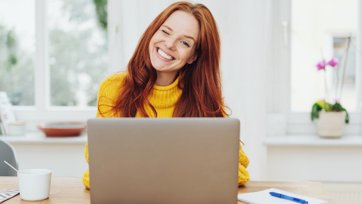 une jeune femme rousse qui fait un clin d'œil