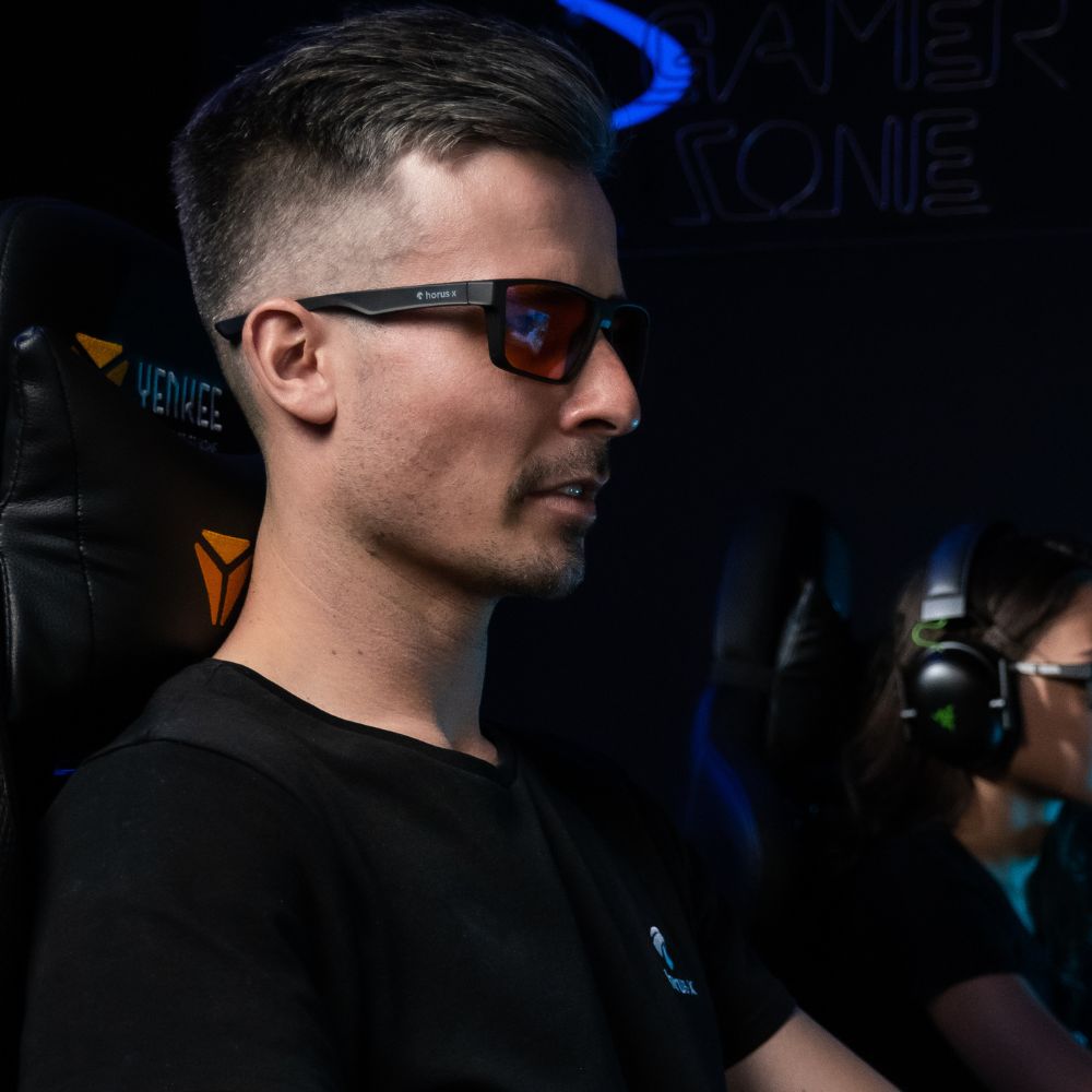 Modèle homme porte lunettes gaming One ambrées en jouant sur PC gaming